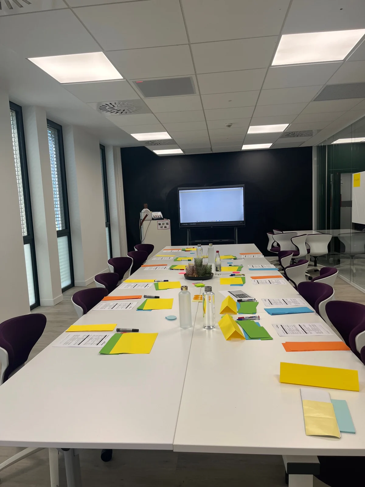 Training tables prepared with worksheets, coloured cards and pens.